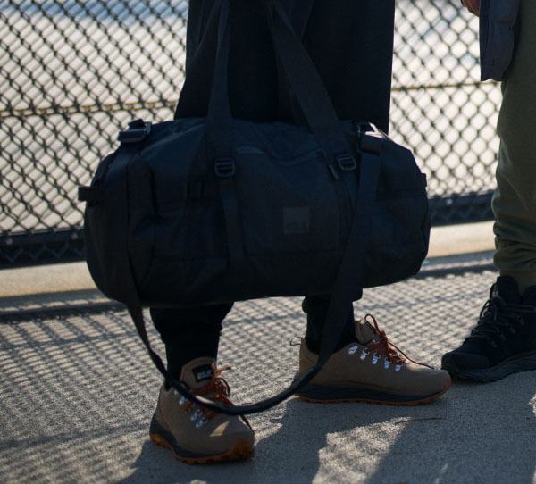 Two men with a duffel bag