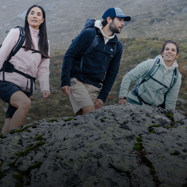 Three friends hiking through a rocky mountain landscape